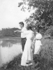 Man and Two Women Standing on River Bank (Summer 1914)