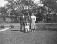 Man, woman, and young boy on scooter in yard
